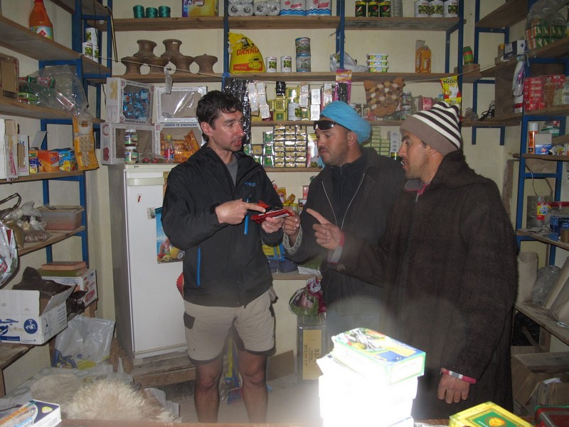 Morocco, Tagoudite. Buying food in rural shop boutique