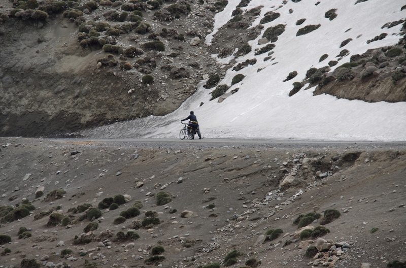 Morocco, High Atlas. Cyclist near snow pass