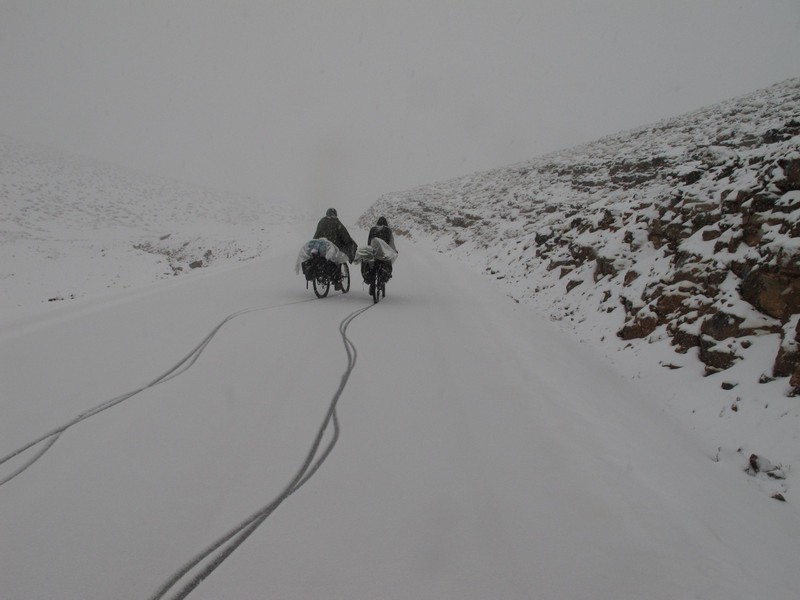 Morocco, High Atlas. Two cyclists under snow.