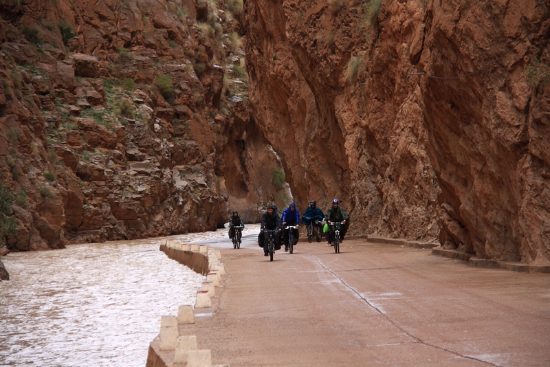 Morocco, Dades gorge. Bicycle group on narrow road near river