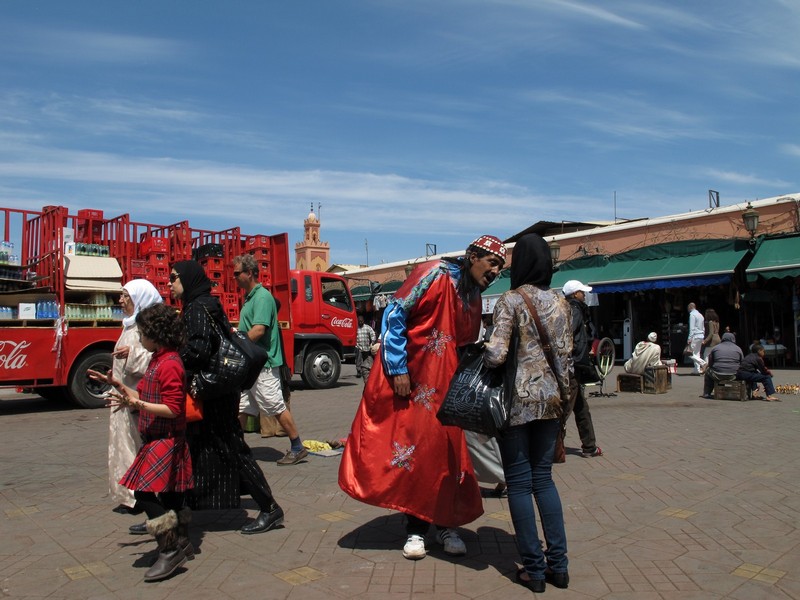 Morocco, Marrakesh. Jemaa el Fnaa scene. Man in red