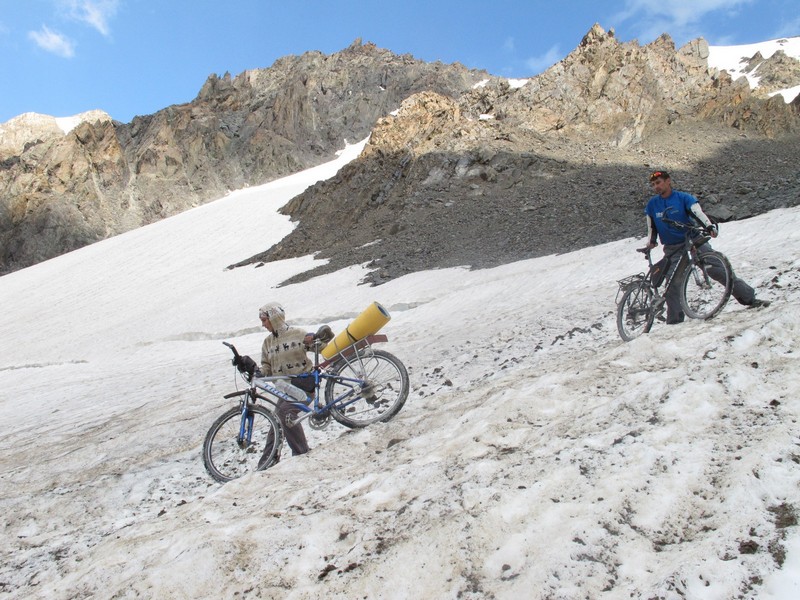 Tajikistan, Rost pass. Haul bicycles through glaciers snow