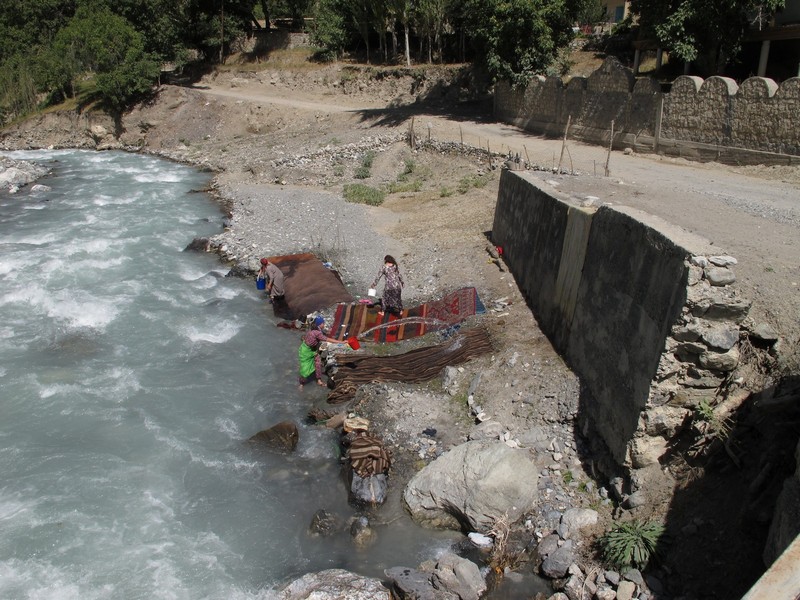 Tavasang pass. Tajik women wash carpets in river